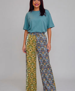 Model draagt Bob & Bill Felin pantalon met wijde pijpen, all-over print, elastische taille en ceintuur in linnenmix.