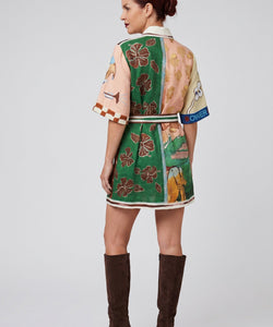 Model draagt een Bob & Bill resort jurk met all-over print, korte mouwen, kraag en ceintuur van linnen en katoen.