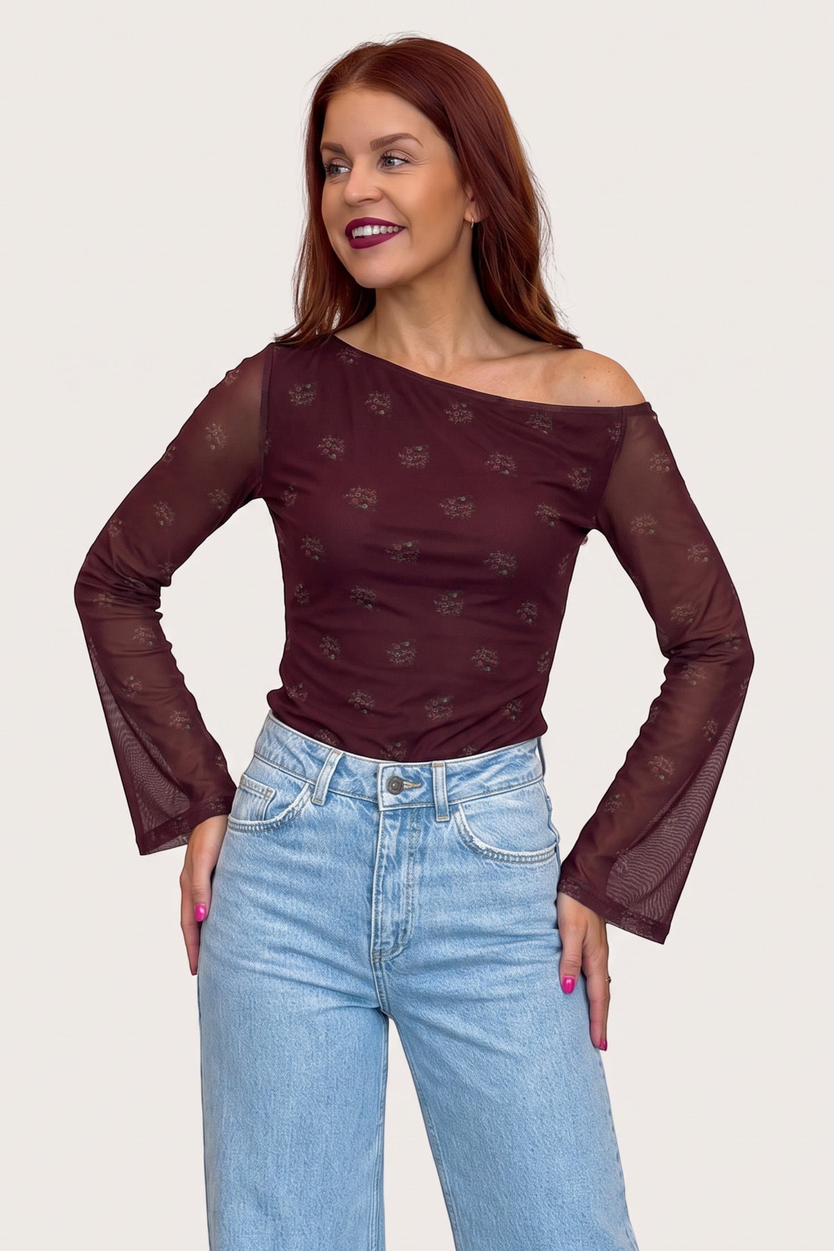 Bob & Bill bordeaux mesh top met off-shoulder halslijn en bloemenprint gedragen door een model met rood haar.