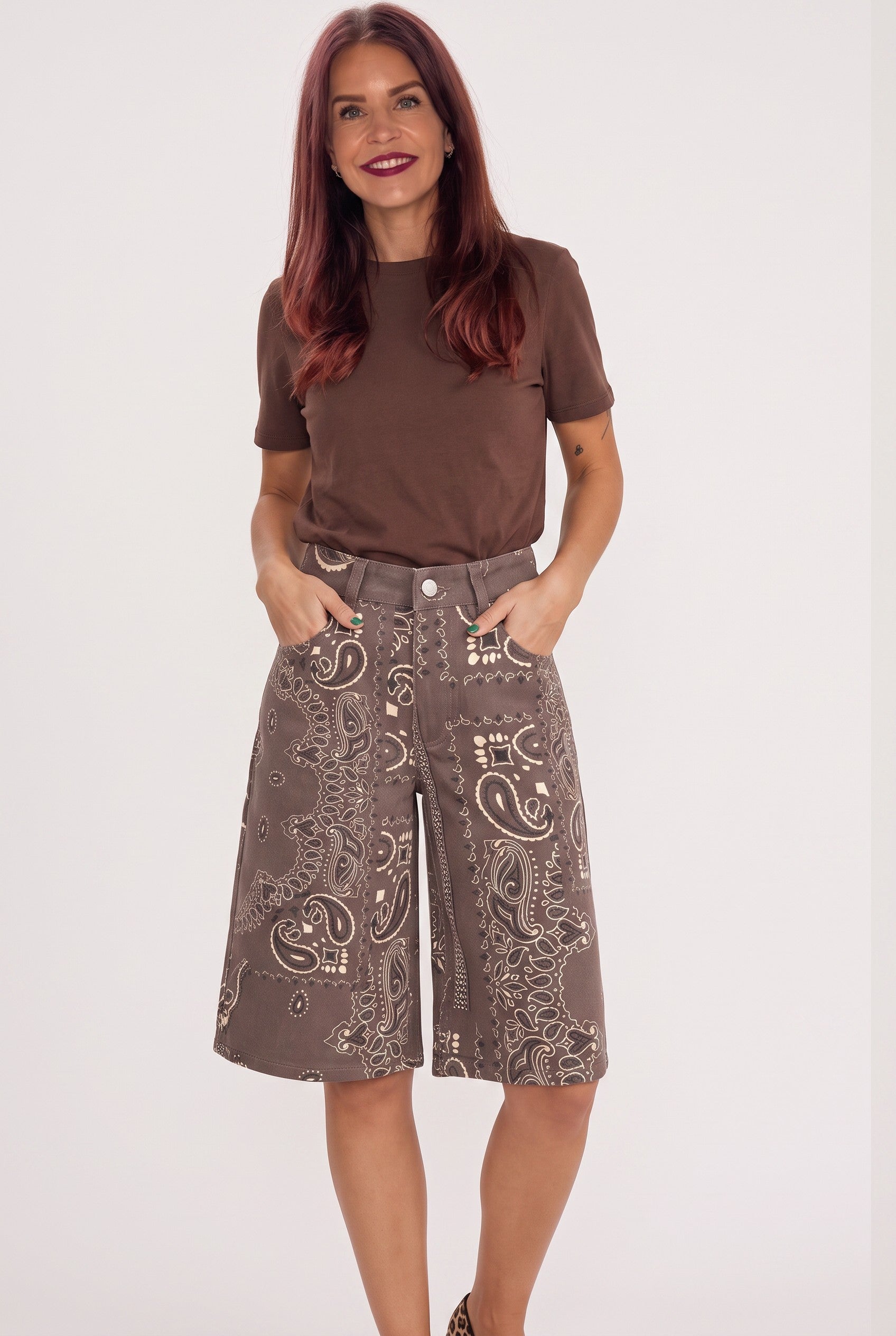 Bob & Bill Yuna brown jorts with a white paisley print, mid-high waist, and pockets worn with a brown t-shirt.