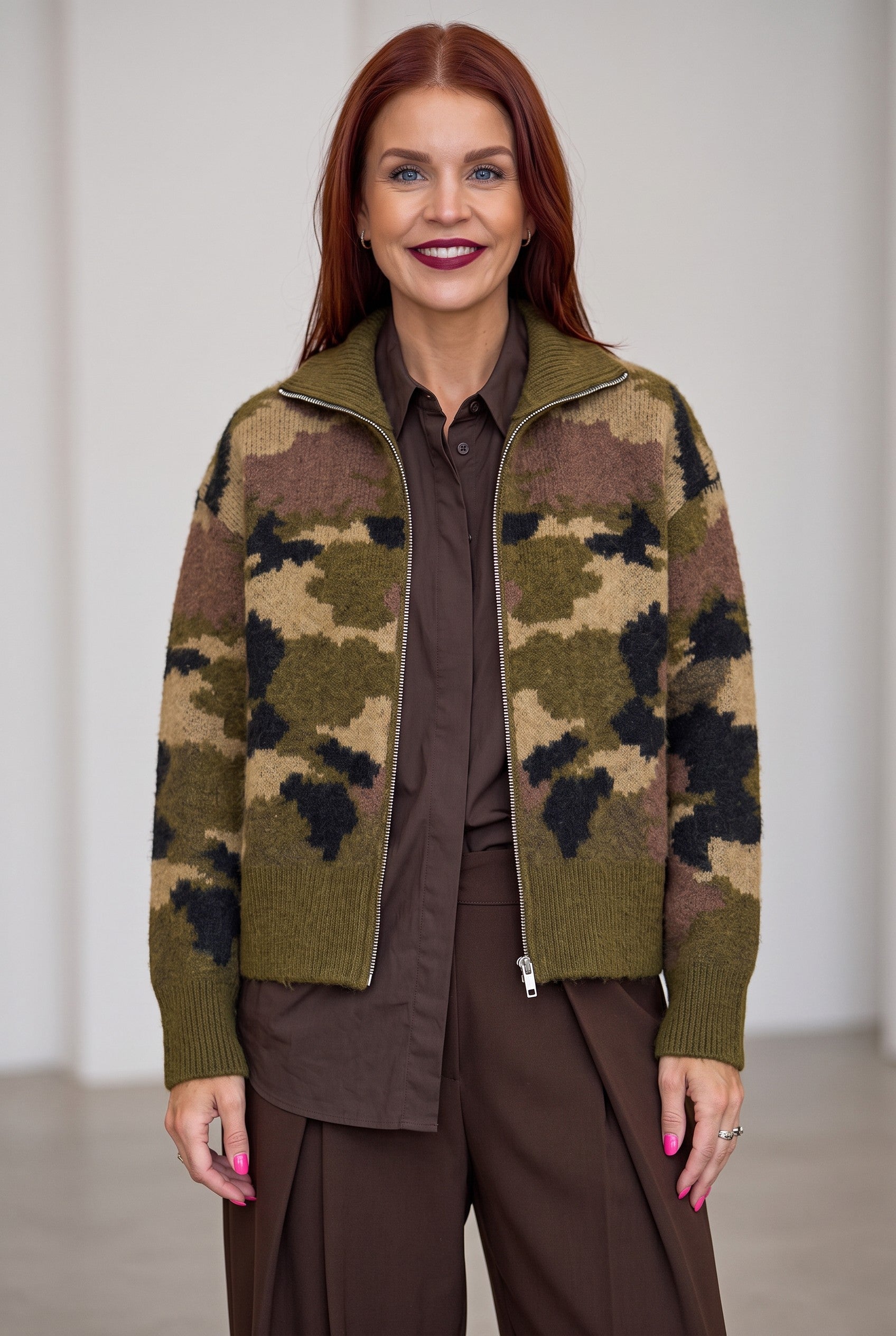 Bob & Bill camo print knit cardigan with a front zipper, worn by a woman in a brown shirt and trousers.