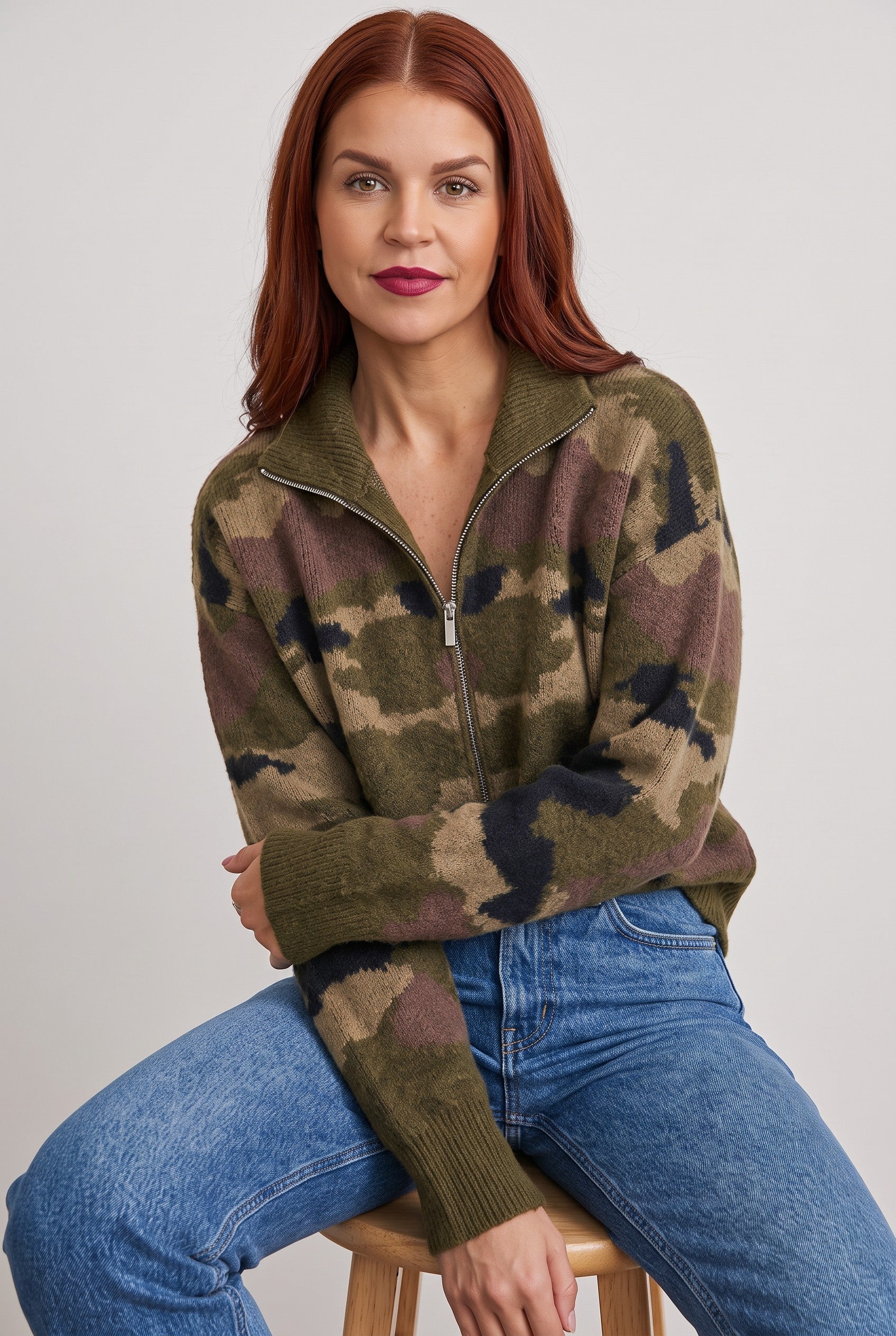 Bob & Bill camo print knit cardigan with a front zipper, worn by a woman with red hair against a neutral background.