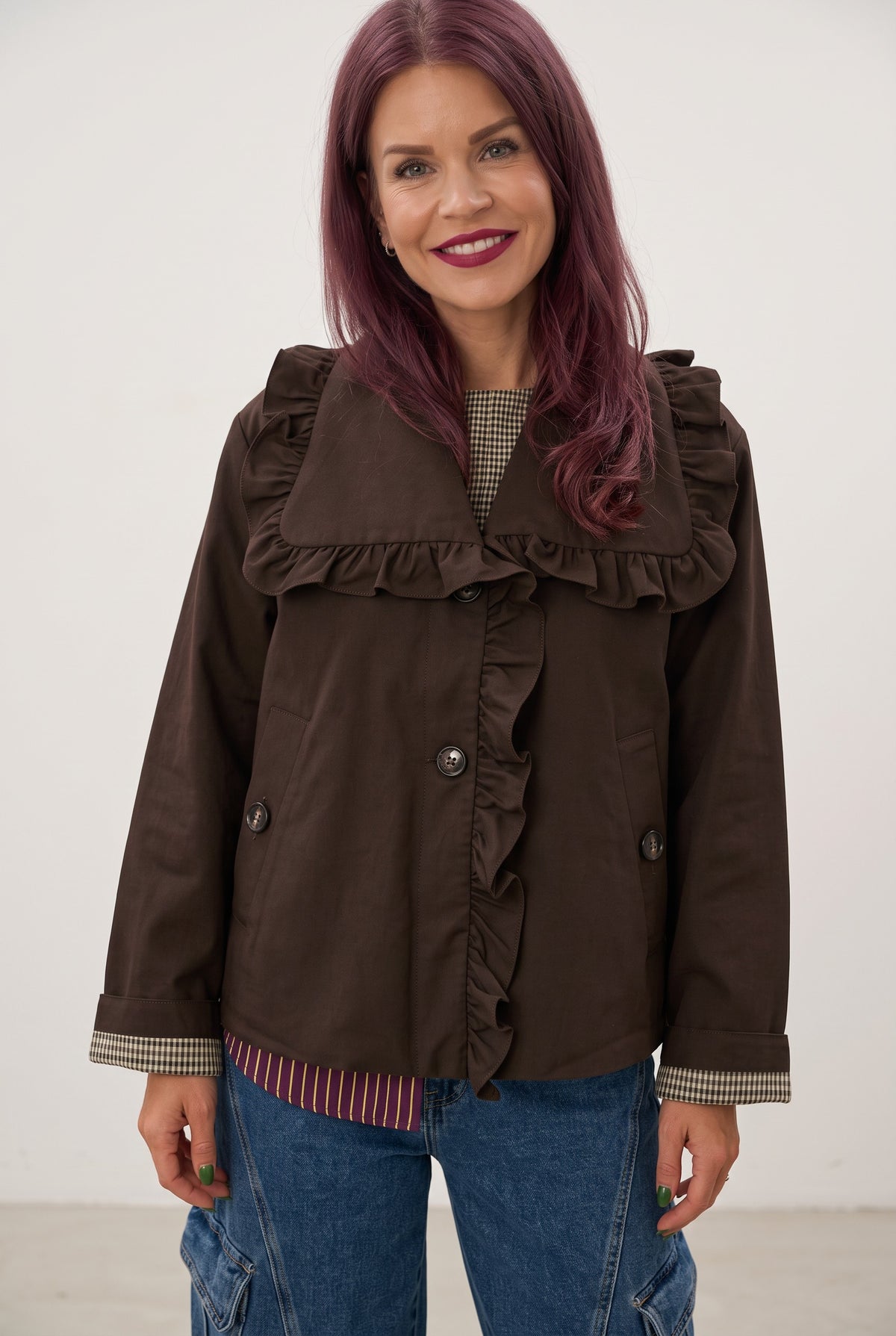 Bob & Bill YAS coffee bean brown short trench coat with ruffle collar and button closure worn by a smiling woman