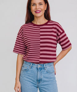 Model draagt Bob & Bill Frankie gestreept t-shirt in bordeaux en roze met ronde hals en relaxte pasvorm