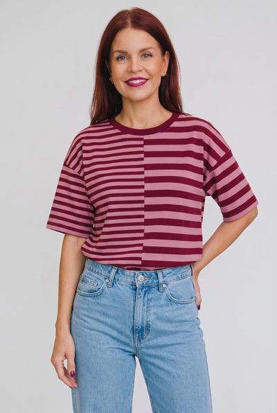 Model draagt Bob & Bill Frankie gestreept t-shirt in bordeaux en roze met ronde hals en relaxte pasvorm