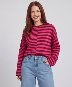 Model wearing a Bob & Bill fuchsia and dark pink striped long-sleeve knit shirt with a relaxed fit and round neck.