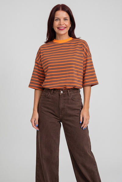 Model draagt Bob & Bill Lulu gestreept T-shirt in oranje en bruin met ronde hals en relaxte pasvorm