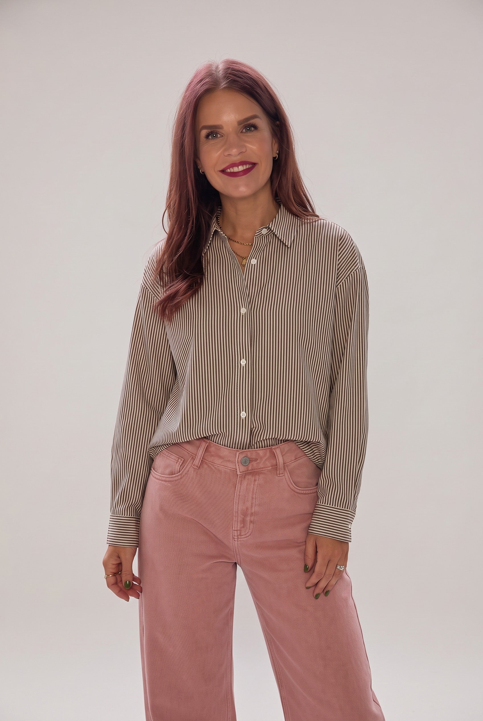 Woman wearing a beige and brown striped cotton Marao blouse from Bob & Bill with pink trousers