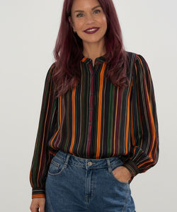 Bob & Bill Mille blouse with long sleeves and a multi-colored vertical stripe print, worn with blue denim jeans.