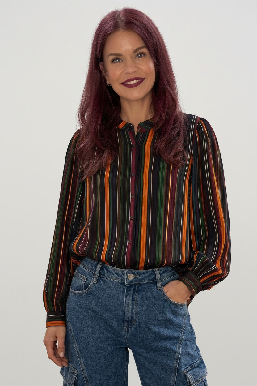 Bob & Bill Mille blouse with long sleeves and a multi-colored vertical stripe print, worn with blue denim jeans.