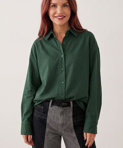 Model wearing a Bob & Bill dark green loose fit Nancy blouse with long sleeves and a classic collar