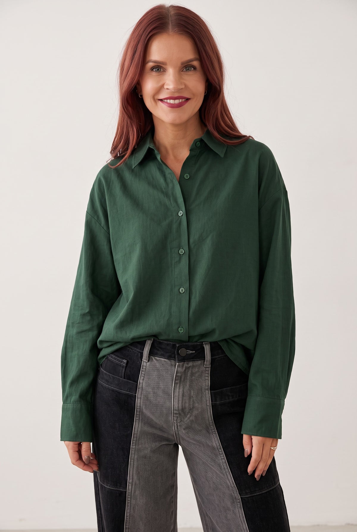 Model wearing a Bob & Bill dark green loose fit Nancy blouse with long sleeves and a classic collar