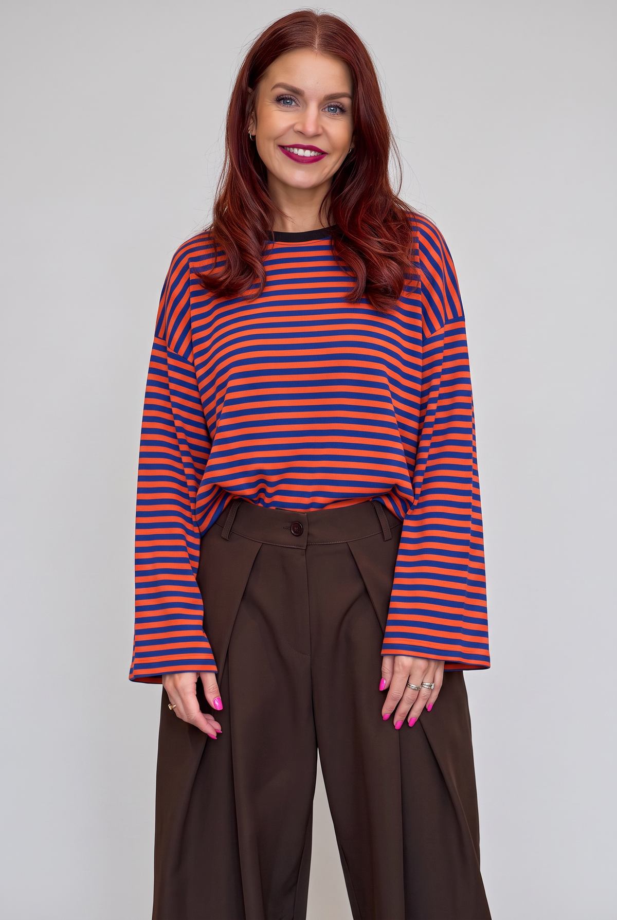 Bob & Bill Sammie long-sleeve knit shirt with orange and blue horizontal stripes and a round neck worn by a woman