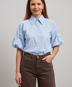 Bob & Bill lichtblauwe katoenen blouse met korte pofmouwen, kraag en pareldetails. Recht gesneden en licht aangesloten.