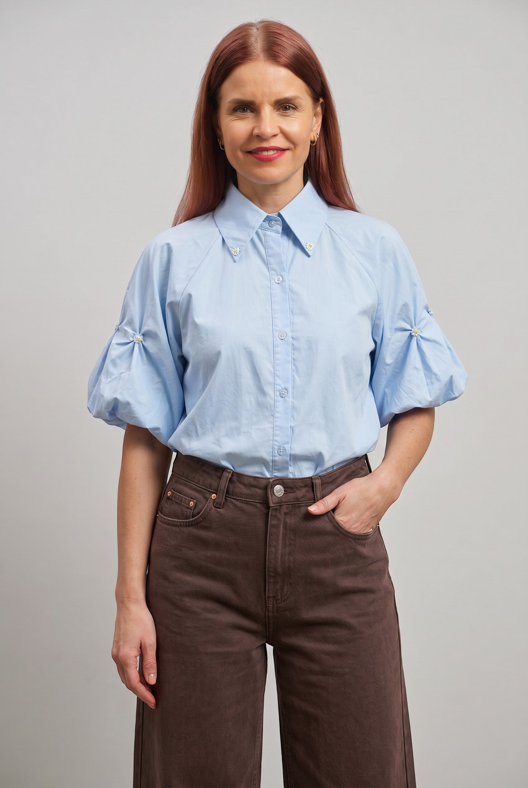 Bob & Bill lichtblauwe katoenen blouse met korte pofmouwen, kraag en pareldetails. Recht gesneden en licht aangesloten.