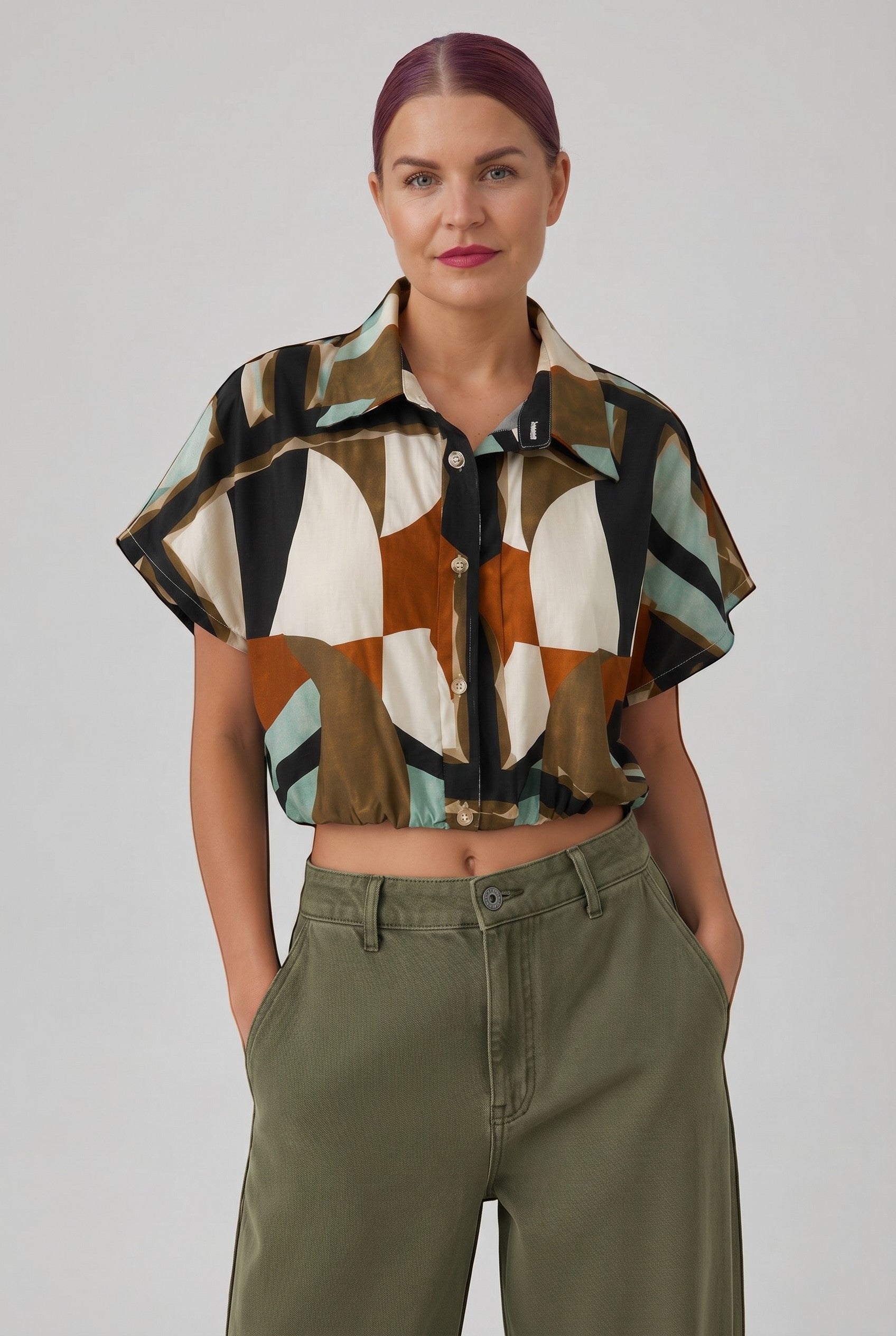 Bob & Bill GEO BLOUSE, een cropped blouse met korte mouwen, kraag en geometrische print in zwart, wit, bruin en groen. Gemaakt van 100% katoen.