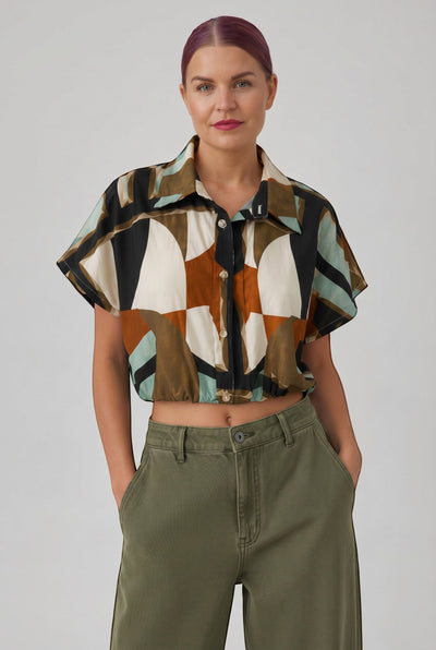 Bob & Bill GEO BLOUSE, een cropped blouse met korte mouwen, kraag en geometrische print in zwart, wit, bruin en groen. Gemaakt van 100% katoen.